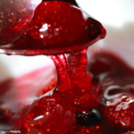 Photo of a spoon covered in strawberry jam